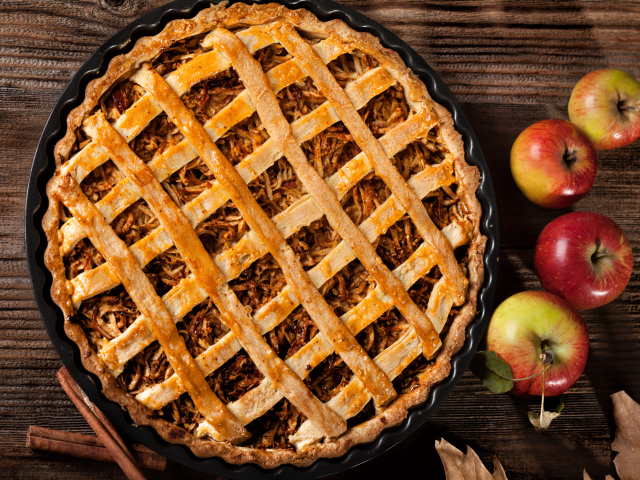 Вкусный горячий пирог на столе с яблоками 