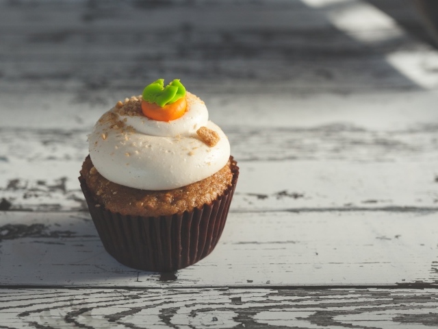 Вкусный сладкий кекс с кремом на деревянном столе 