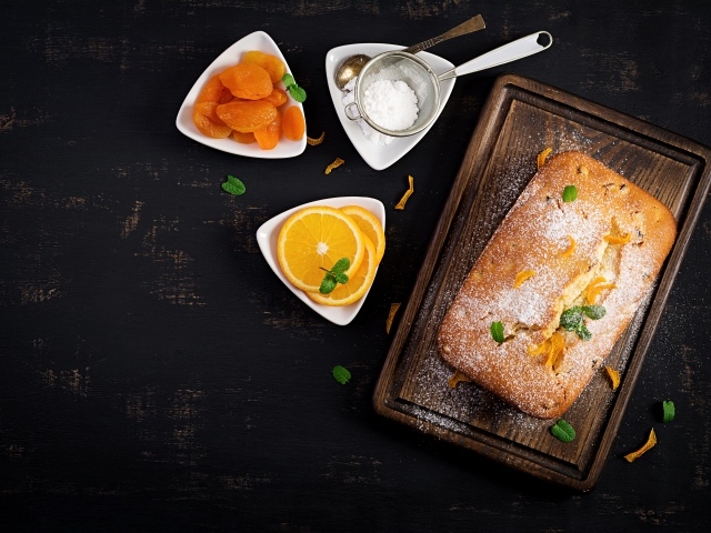 Свежий сладкий пирог на столе с курагой и апельсином