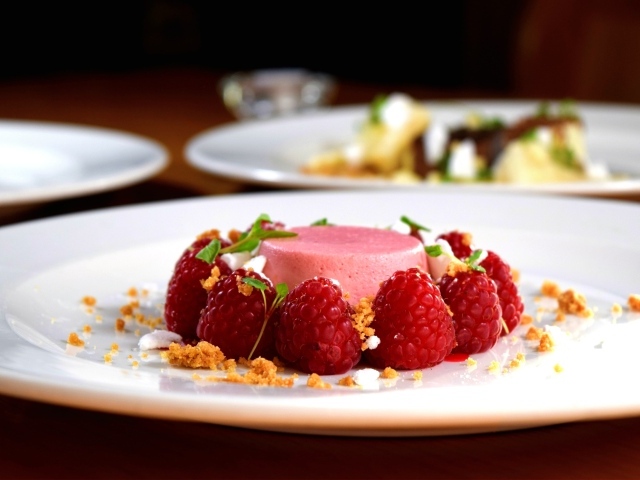 Фруктовое суфле на большой белой тарелке с ягодами малины