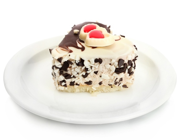 Пирожное в форме сердца с шоколадом на белой тарелке