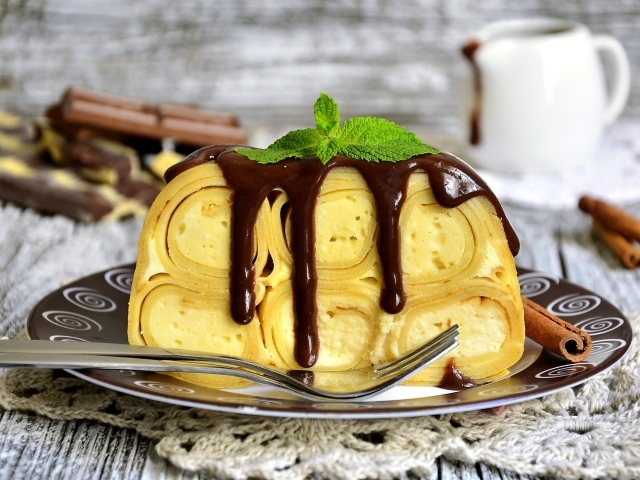 Блинный торт с творогом и шоколадом на тарелке 