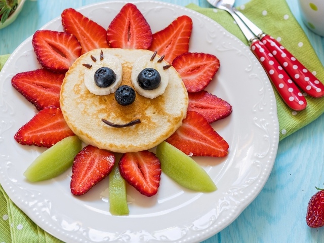 Оладьи с фруктами и ягодами на тарелке