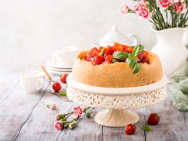 Песочный пирог с клубникой на столе с цветами гвоздики