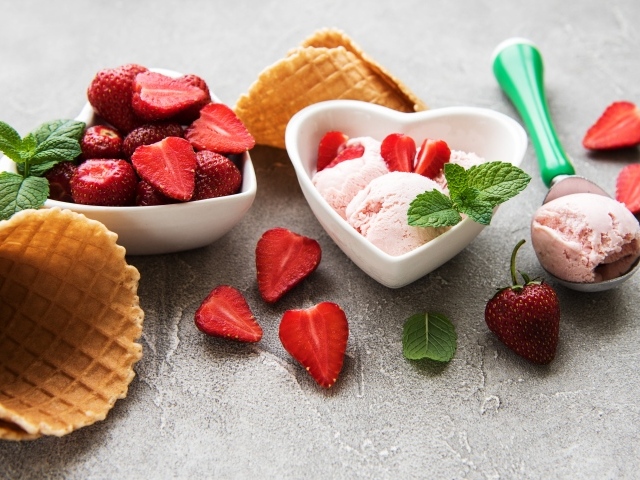 Вкусное мороженое на столе с клубникой и вафельными рожками