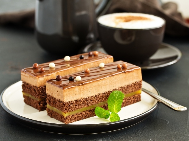 Два пирожных на тарелке с чашкой кофе 