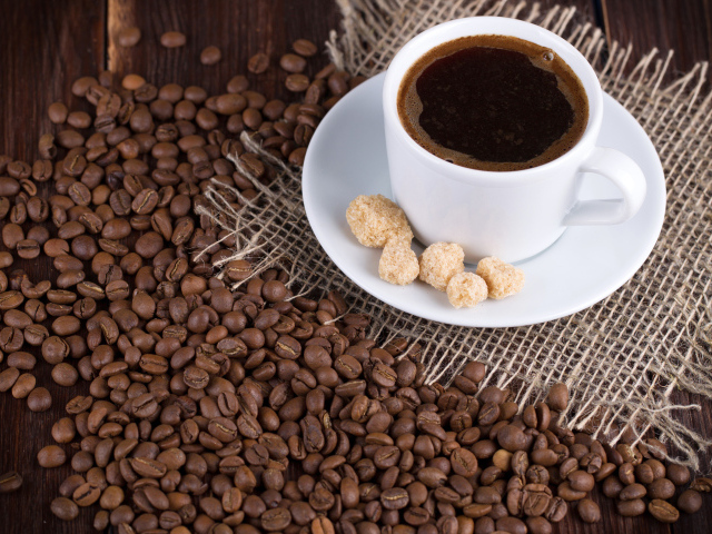 Чашка кофе с зернами на столе 