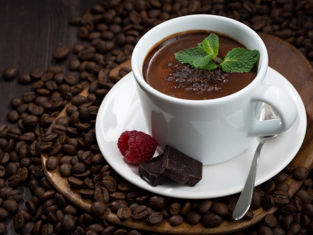 Чашка горячего шоколада на столе с кофейными зернами