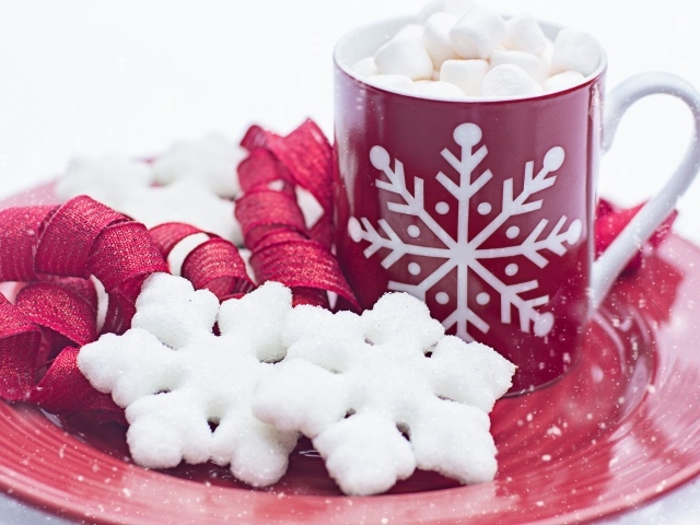 Чашка горячего шоколада с маршмеллоу на тарелке со снежинками