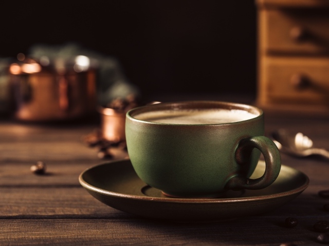 Большая чашка кофе на столе с кофейными зернами 