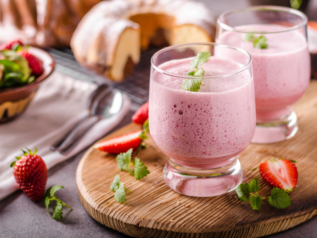 Ягодное смузи в стаканах на столе с клубникой