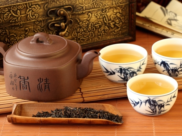 Китайский чайник на столе с чашками