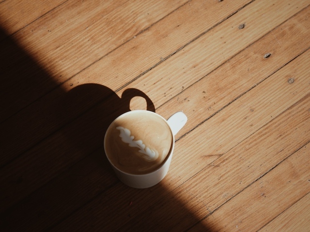 Чашка капучино с рисунком на деревянном столе