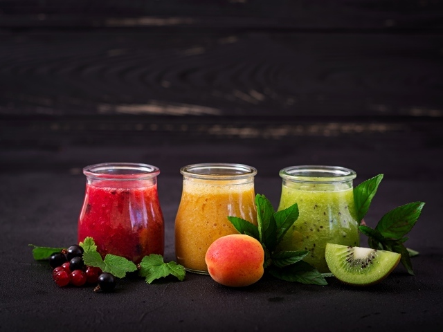Фруктовое смузи в баночках на столе 