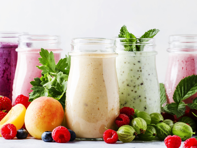Банки со смузи на столе с ягодами 