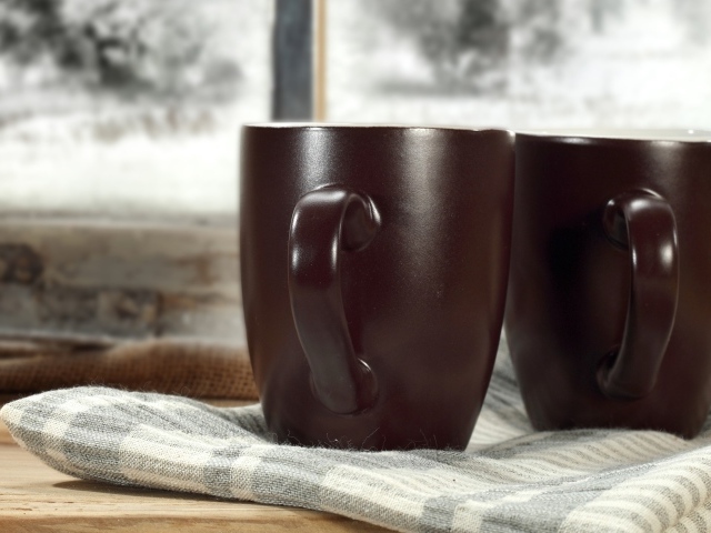 Две коричневые чашки кофе на столе с шарфом