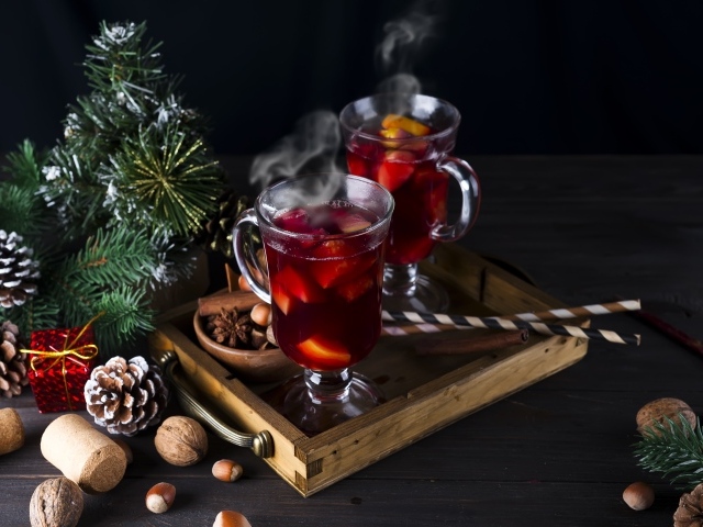Два стакана горячего глинтвейна на столе с еловой веткой