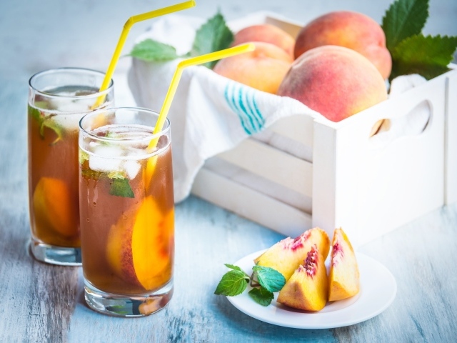 Два стакана сока на столе с персиками