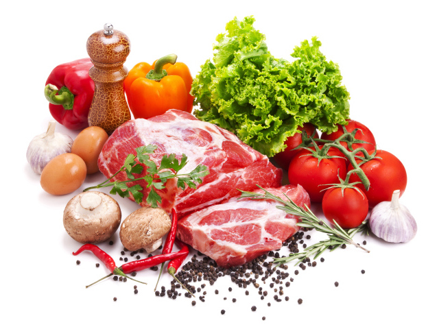 Кусок мяса на белом фоне с овощами и специями