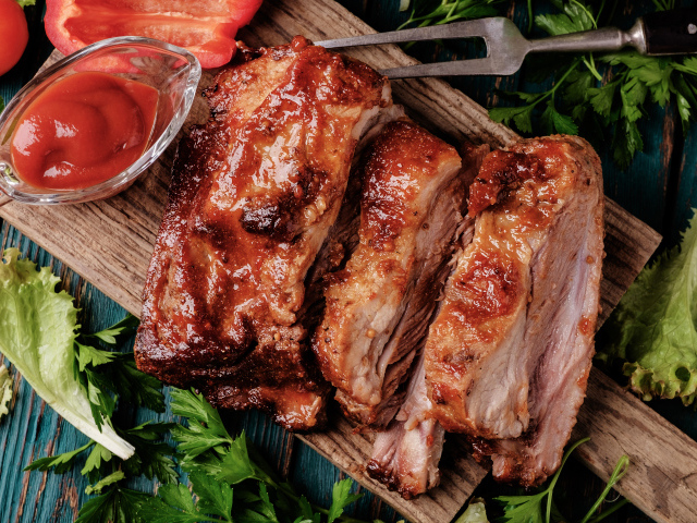 Сочный кусок запеченного мяса на столе с соусом