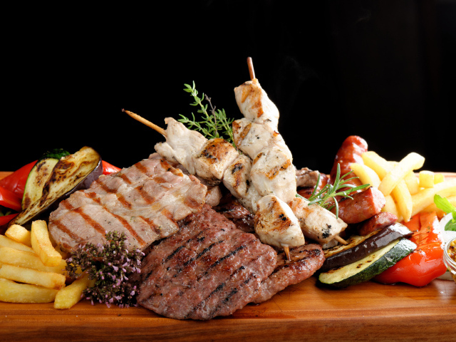 Мясные продукты на столе с картофелем фри 