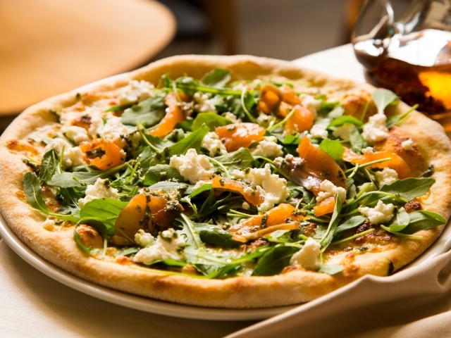 Аппетитная пицца с рыбой и зеленью на столе