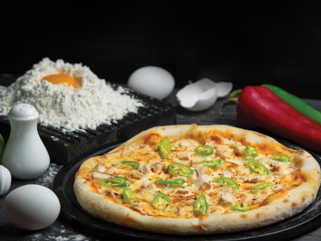 Пицца на столе с яйцами и перцем