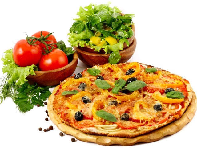 Пицца на столе с овощами и зеленью на белом фоне