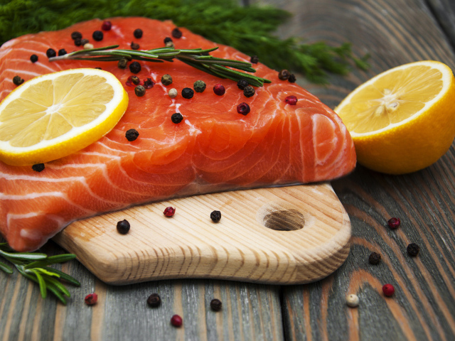 Кусок красной рыбы с лимоном и черным перцем