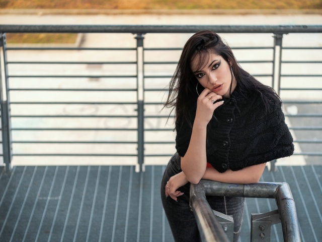 Красивая девушка стоит на ступеньках у перил 