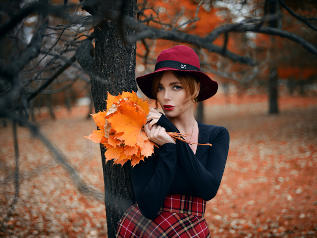 Девушка стоит у дереве с желтыми листьями осенью