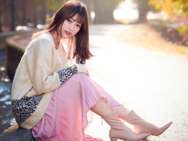 Девушка азиатка сидит на земле 