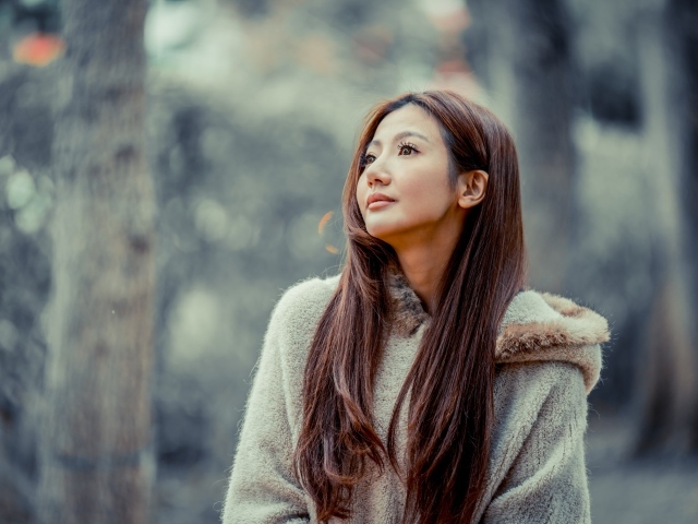 Длинноволосая девушка азиатка смотрит в сторону