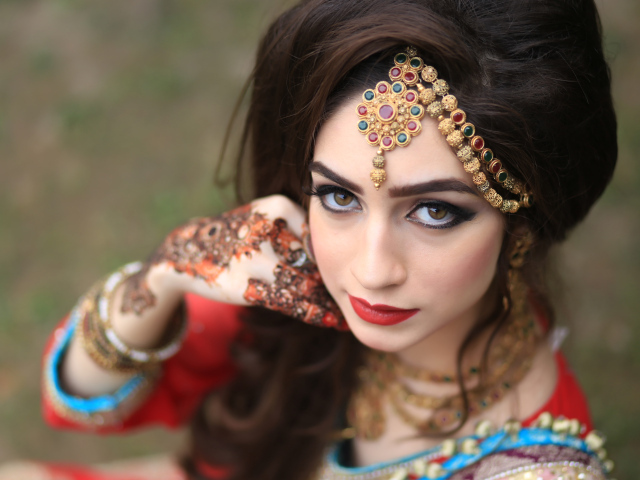 Красивая кареглазая девушка в индийском костюме с рисунками на руках 