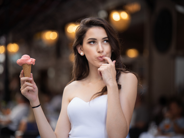 Красивая девушка шатенка с мороженым в руке