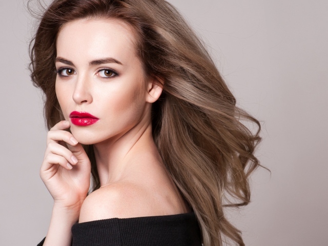 Красивая шатенка с красными губами на сером фоне
