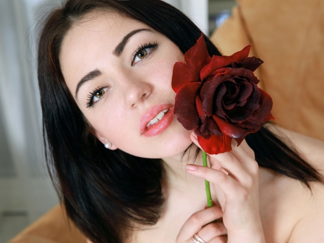 Красивая брюнетка с розой в руке крупным планом
