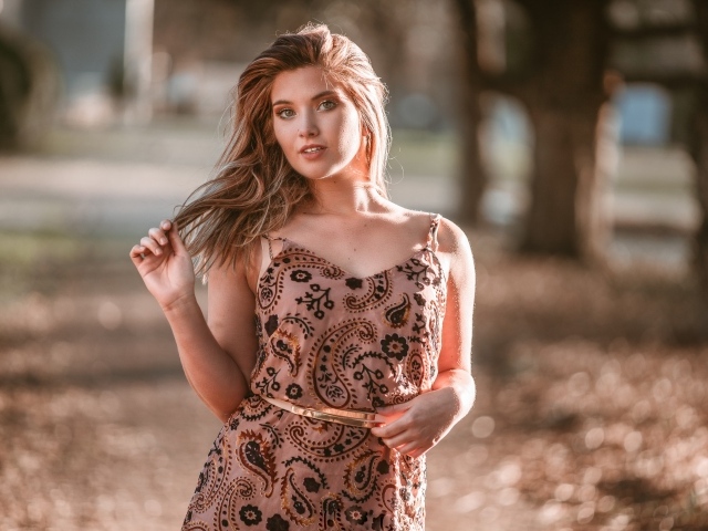 Красивая девушка в платье в лучах солнца летом