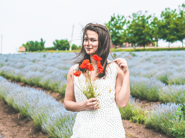 Красивая девушка в платье с букетом маков