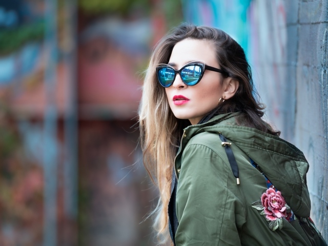 Красивая девушка в куртке и солнечных очках