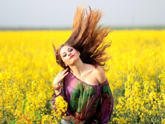 Красивая девушка на поле с желтыми цветами