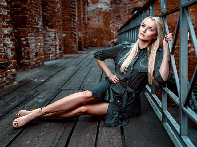 Красивая девушка сидит на деревянном полу