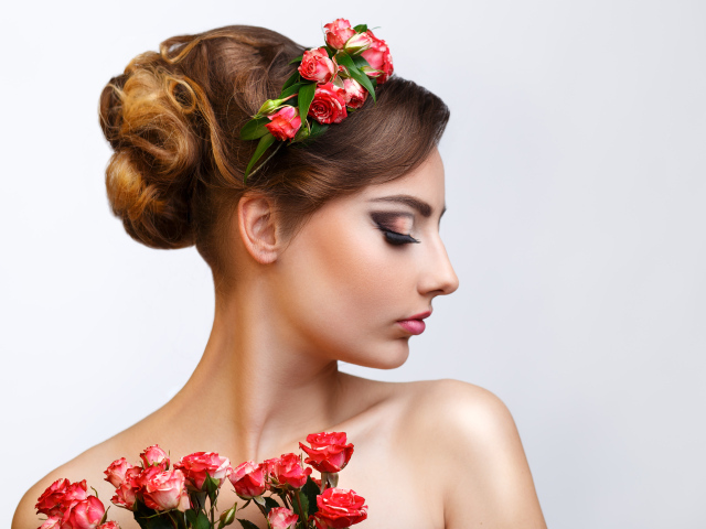 Красивая девушка с прической и венком из роз в волосах 