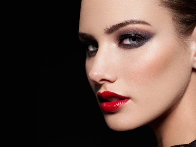 Красивая девушка с яркой помадой на губах на черном фоне