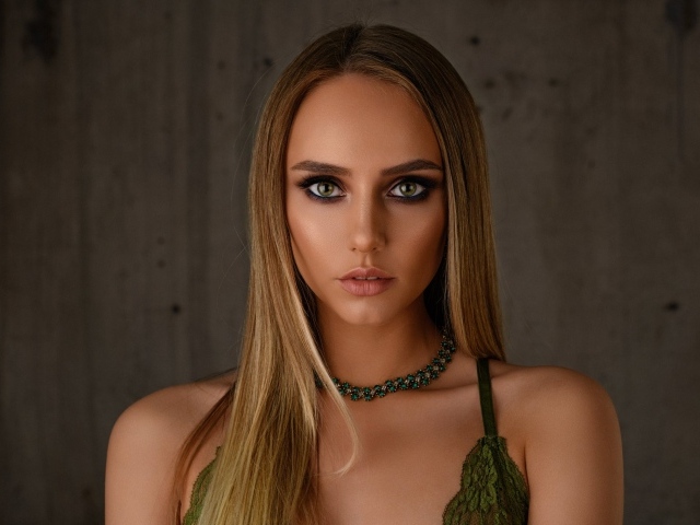 Красивая длинноволосая блондинка с украшением на шее 