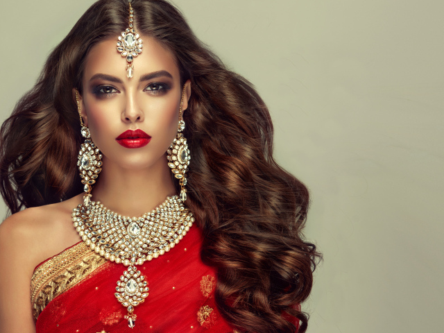 Красивая длинноволосая шатенка в индийском сари с украшениями