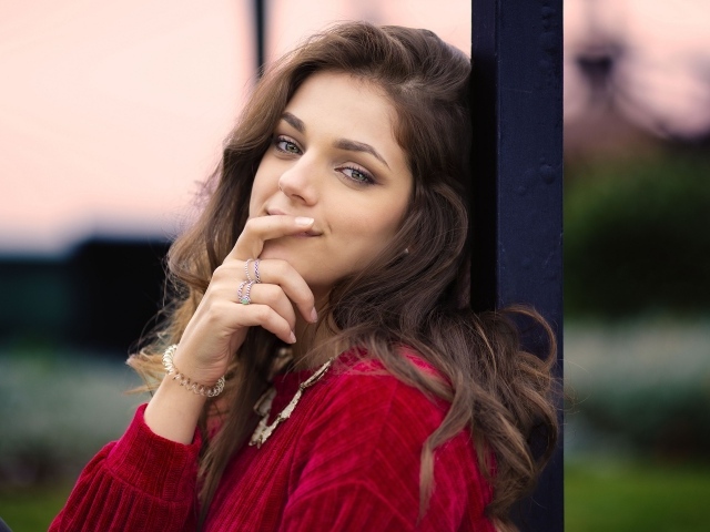 Красивая длинноволосая шатенка с рукой у лица