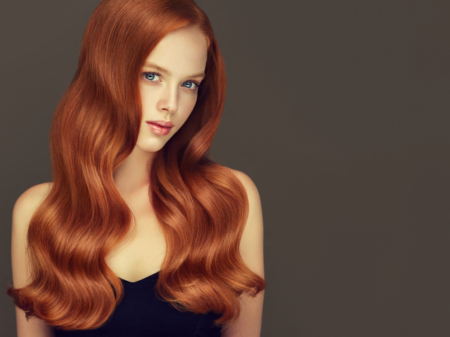 Красивая рыжеволосая голубоглазая девушка на сером фоне