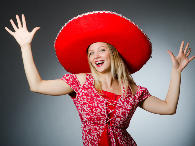 Красивая улыбающаяся блондинка в большой красной шляпе