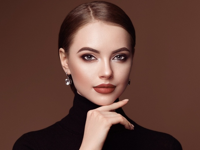 Красивая стильная девушка шатенка на коричневом фоне